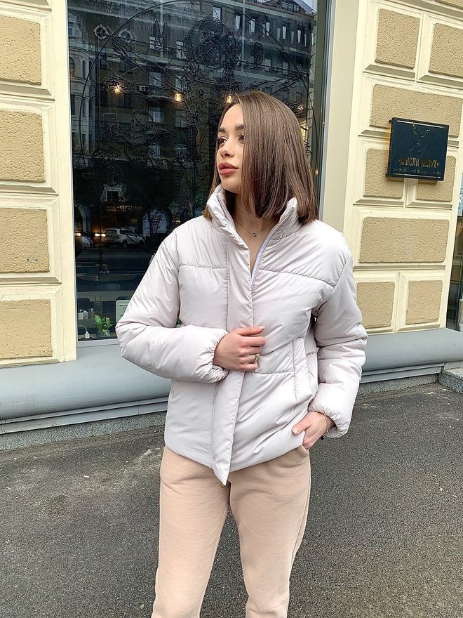 Жіноча куртка молочного кольору з фурнітурою кольору срібло